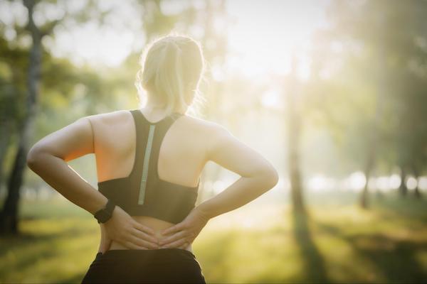 A female jogger experiencing lower back pain